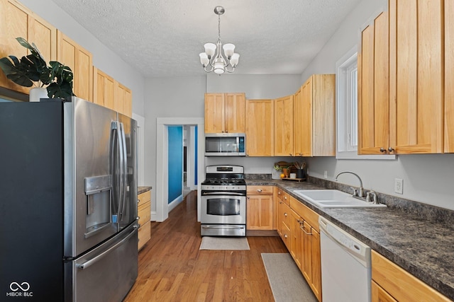 245 S Washington St, Danville, IN 46122 - kitchen featuring appliances with stainless steel finishes, a sink, light brown cabinets, a chandelier, and dark countertops