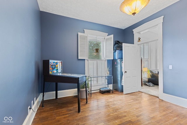 245 S Washington St, Danville, IN 46122 - home office featuring wood finished floors, baseboards, and a textured ceiling