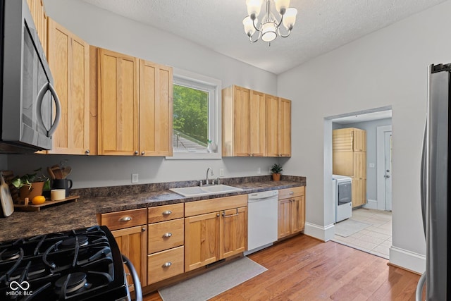 245 S Washington St, Danville, IN 46122 - kitchen featuring stainless steel appliances, a sink, light wood-style floors, dark countertops, and light brown cabinets