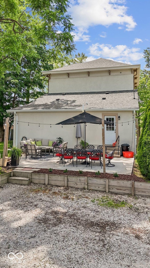 245 S Washington St, Danville, IN 46122 - back of property featuring a patio, an outdoor living space, stucco siding, and roof with shingles