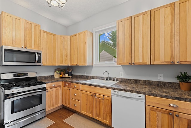 245 S Washington St, Danville, IN 46122 - kitchen with stainless steel appliances, a sink, light brown cabinetry, dark wood-style floors, and dark countertops