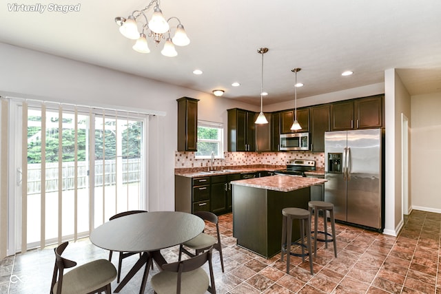 4650 Blue Marlin Way, Indianapolis, IN 46239 - kitchen with stainless steel appliances, decorative backsplash, a center island, dark brown cabinets, and recessed lighting