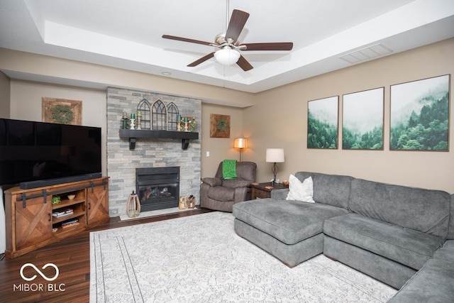 845 S Bay, North Vernon, IN 47265 - living room with a raised ceiling, wood finished floors, ceiling fan, and a stone fireplace