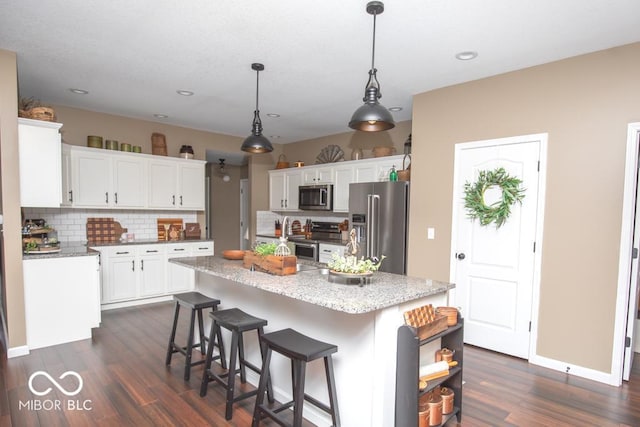 845 S Bay, North Vernon, IN 47265 - kitchen with appliances with stainless steel finishes, a center island, backsplash, dark wood-style flooring, and recessed lighting