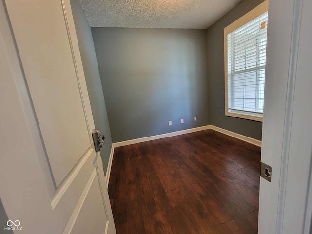 11070 Long Lake Ln, Fishers, IN 46037 - unfurnished room featuring dark wood-style flooring, a textured ceiling, and baseboards
