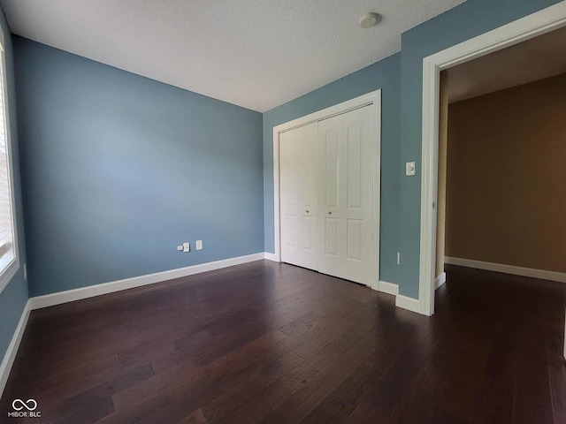 11070 Long Lake Ln, Fishers, IN 46037 - unfurnished bedroom featuring dark wood-style floors, a closet, baseboards, and a textured ceiling