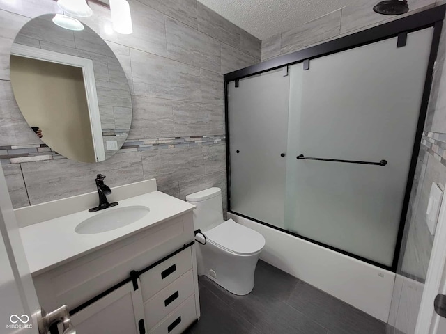 11070 Long Lake Ln, Fishers, IN 46037 - bathroom with tile walls, vanity, toilet, enclosed tub / shower combo, and a textured ceiling
