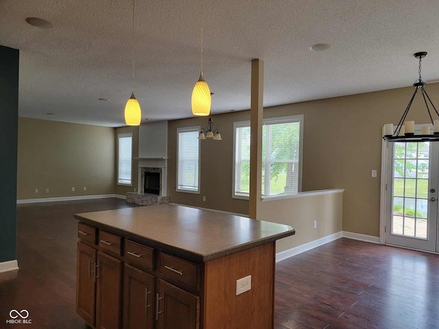 11070 Long Lake Ln, Fishers, IN 46037 - kitchen featuring dark wood-style flooring, baseboards, open floor plan, a textured ceiling, and a fireplace with raised hearth