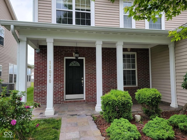 11070 Long Lake Ln, Fishers, IN 46037 - entrance to property with covered porch, brick siding, and central AC