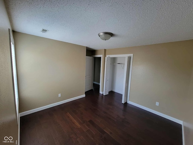 11070 Long Lake Ln, Fishers, IN 46037 - unfurnished bedroom with dark wood-type flooring, a textured ceiling, baseboards, and a closet