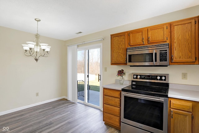 1024 Rotherham Ln, Beech Grove, IN 46107 - kitchen with stainless steel appliances, a chandelier, wood finished floors, brown cabinets, and light countertops