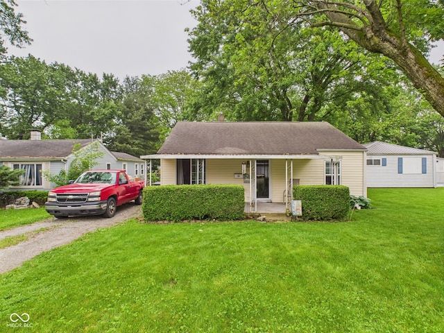 2405 E 9th St, Anderson, IN 46012 - view of front of home with covered porch, a front lawn, and a chimney