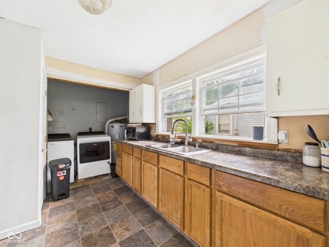 2405 E 9th St, Anderson, IN 46012 - kitchen featuring a sink, stainless steel microwave, dark countertops, stone finish floors, and independent washer and dryer