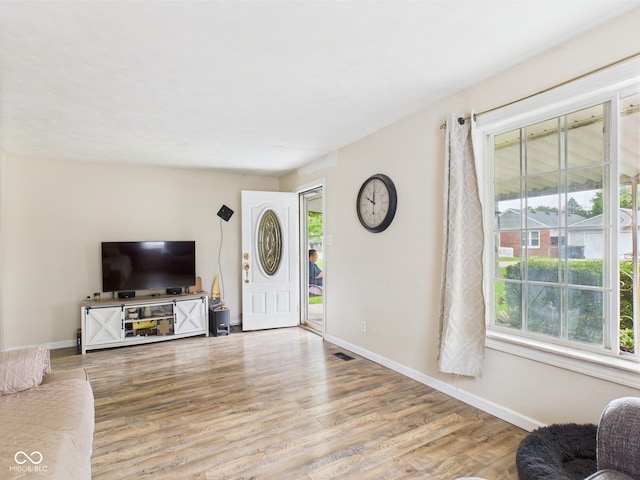 2405 E 9th St, Anderson, IN 46012 - unfurnished living room featuring healthy amount of natural light, wood finished floors, and baseboards