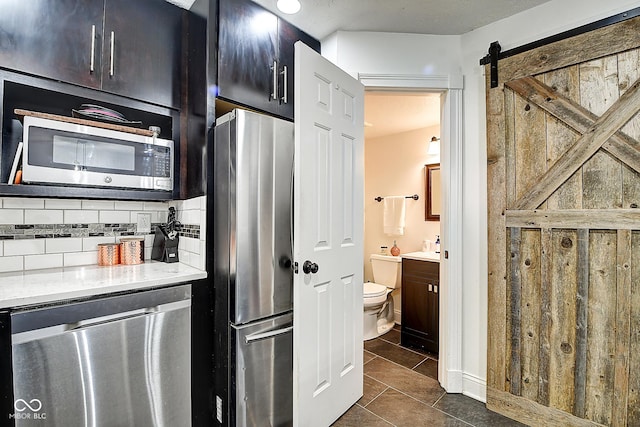 1548 N Park Ave, Indianapolis, IN 46202 - kitchen with appliances with stainless steel finishes, backsplash, dark tile patterned flooring, and light stone countertops