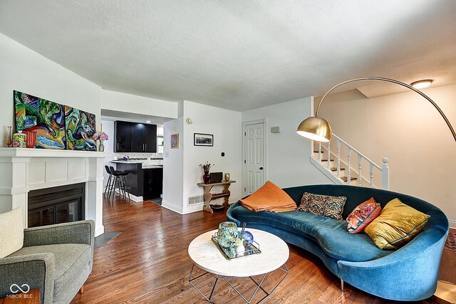 1548 N Park Ave, Indianapolis, IN 46202 - living room featuring wood finished floors, stairs, a fireplace with flush hearth, and baseboards