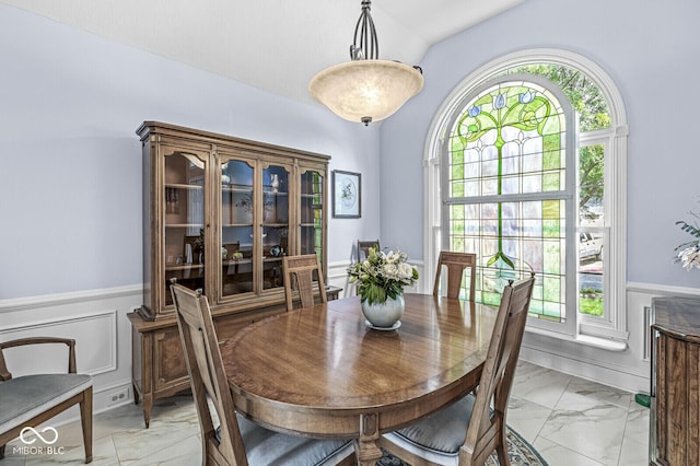 11244 Blackwalnut Pt, Indianapolis, IN 46236 - dining room featuring light marble finish floors, wainscoting, and a decorative wall