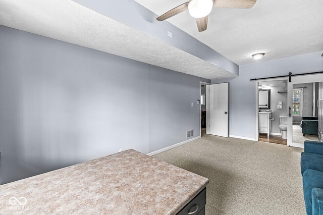 11244 Blackwalnut Pt, Indianapolis, IN 46236 - unfurnished living room featuring a barn door, a ceiling fan, carpet, and a textured ceiling