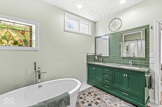11244 Blackwalnut Pt, Indianapolis, IN 46236 - full bathroom with double vanity, a freestanding bath, a textured ceiling, decorative backsplash, and recessed lighting