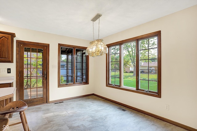 8619 Wrangler Ct, Indianapolis, IN 46217 - unfurnished dining area featuring healthy amount of natural light, a chandelier, and baseboards