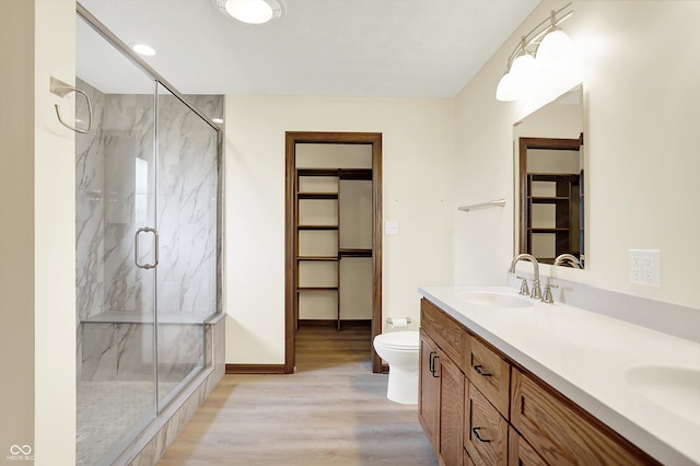 8619 Wrangler Ct, Indianapolis, IN 46217 - full bathroom featuring wood finished floors, toilet, a marble finish shower, double vanity, and baseboards