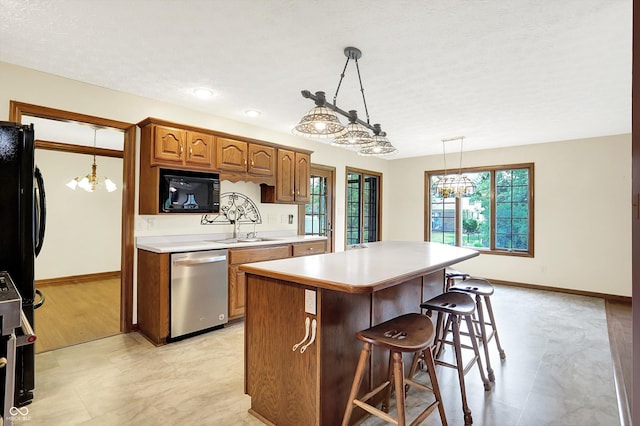 8619 Wrangler Ct, Indianapolis, IN 46217 - kitchen featuring stainless steel dishwasher, baseboards, brown cabinets, a center island, and a textured ceiling