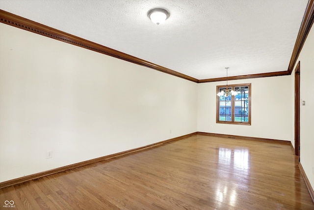 8619 Wrangler Ct, Indianapolis, IN 46217 - empty room with wood finished floors, baseboards, crown molding, a chandelier, and a textured ceiling