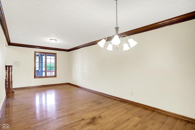 8619 Wrangler Ct, Indianapolis, IN 46217 - empty room with a chandelier, crown molding, wood finished floors, and baseboards