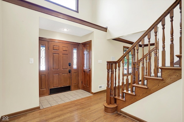 8619 Wrangler Ct, Indianapolis, IN 46217 - entrance foyer featuring wood finished floors, baseboards, stairway, and a towering ceiling
