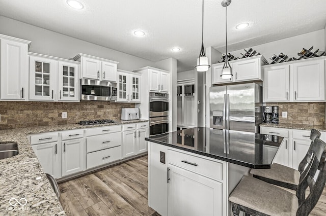4642 Big Run Ct, Indianapolis, IN 46239 - kitchen featuring stainless steel appliances, white cabinets, decorative backsplash, a breakfast bar area, and recessed lighting