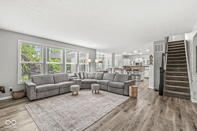 4642 Big Run Ct, Indianapolis, IN 46239 - living area featuring wood finished floors, a textured ceiling, stairway, and baseboards