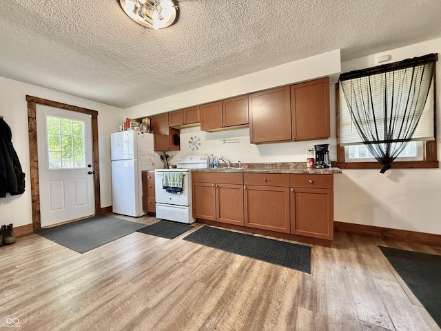 1126 S 20th St, New Castle, IN 47362 - kitchen featuring white appliances, light wood-type flooring, baseboards, a textured ceiling, and a sink