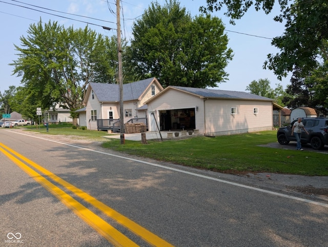 317 Washington St, Clay City, IN 47841 - view of front facade with an attached garage, a front lawn, driveway, and an outbuilding