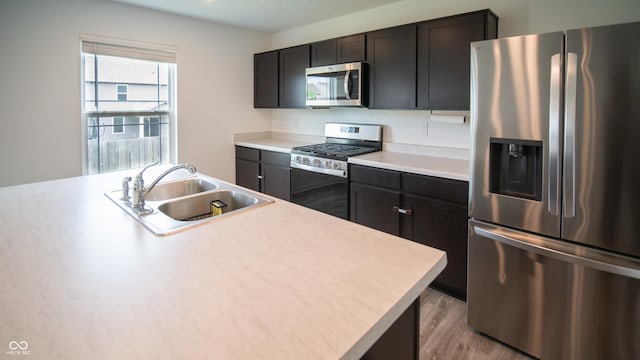 2916 W Bargello Ln, Monrovia, IN 46157 - kitchen with appliances with stainless steel finishes, a sink, light countertops, and light wood-type flooring