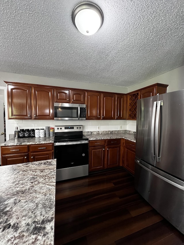 585 Fireside Dr, Greenwood, IN 46143 - kitchen featuring stainless steel appliances, a textured ceiling, and dark wood finished floors