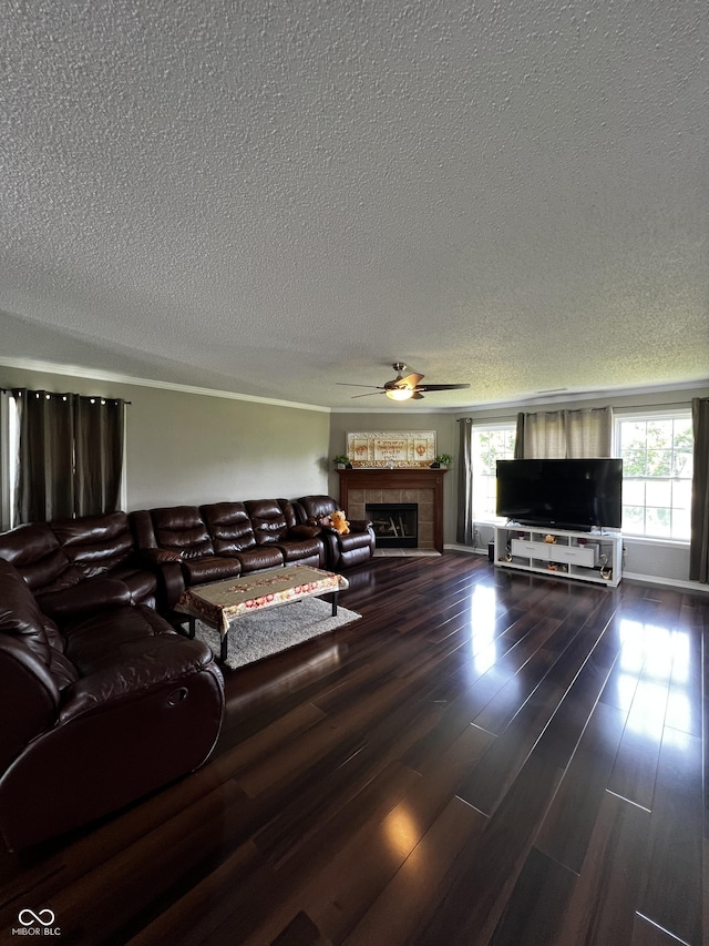 585 Fireside Dr, Greenwood, IN 46143 - living area with a textured ceiling, a tiled fireplace, ceiling fan, and wood finished floors