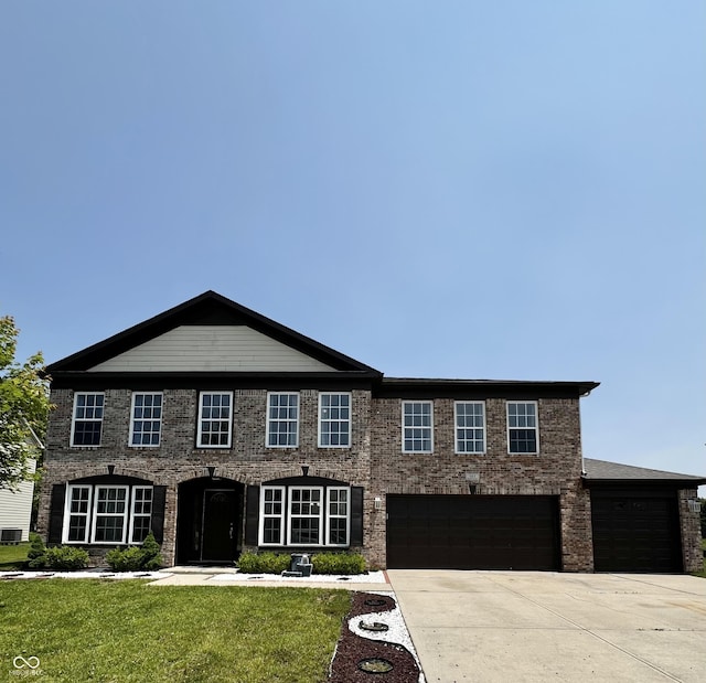 585 Fireside Dr, Greenwood, IN 46143 - view of front of house featuring concrete driveway, a front lawn, an attached garage, and brick siding