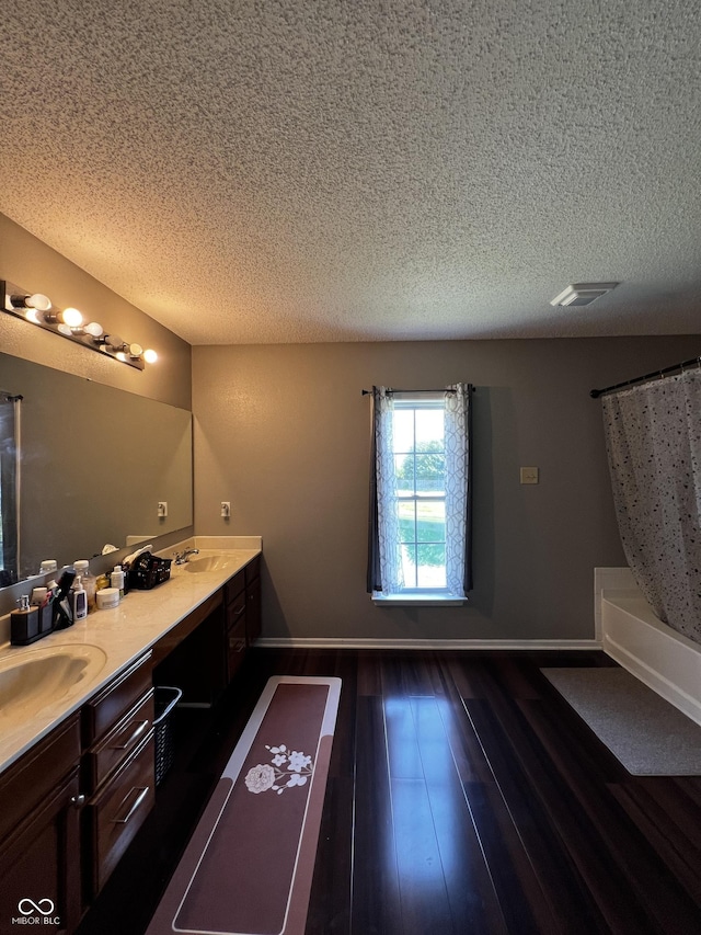 585 Fireside Dr, Greenwood, IN 46143 - full bathroom featuring double vanity, a textured ceiling, and wood finished floors
