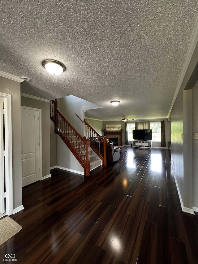 585 Fireside Dr, Greenwood, IN 46143 - hallway featuring wood finished floors, stairs, a textured ceiling, and crown molding