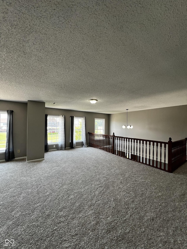585 Fireside Dr, Greenwood, IN 46143 - carpeted spare room featuring a textured ceiling, a chandelier, and plenty of natural light