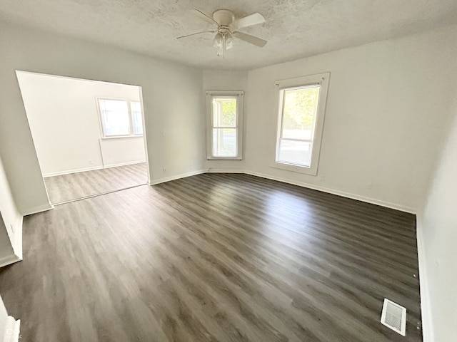 307 N Arlington Ave, Indianapolis, IN 46219 - empty room featuring healthy amount of natural light, ceiling fan, dark wood-style floors, a textured ceiling, and baseboards