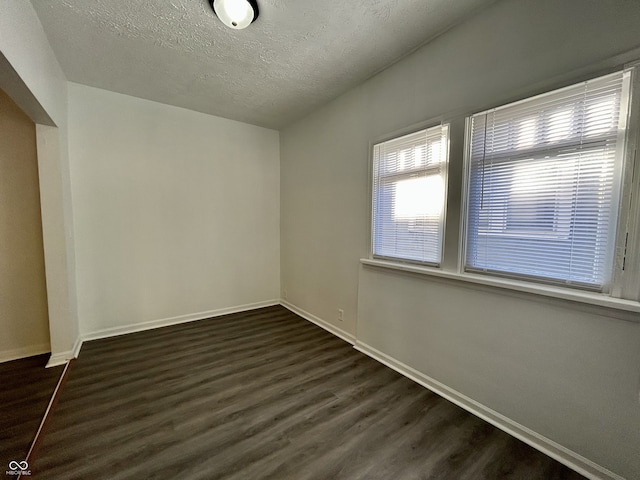 307 N Arlington Ave, Indianapolis, IN 46219 - empty room featuring dark wood-type flooring, baseboards, and a textured ceiling