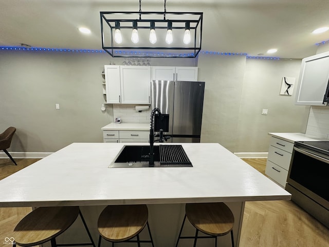 38 Hendricks Pl, Indianapolis, IN 46201 - kitchen featuring stainless steel appliances, tasteful backsplash, light countertops, and white cabinets