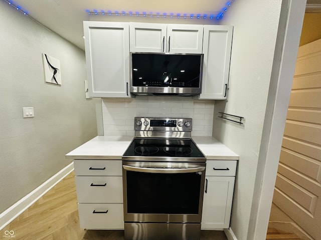 38 Hendricks Pl, Indianapolis, IN 46201 - kitchen with appliances with stainless steel finishes, tasteful backsplash, light countertops, and white cabinets