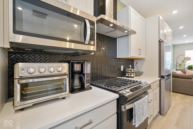 2125 Coretta Way, Indianapolis, IN 46202 - kitchen featuring stainless steel appliances, wall chimney exhaust hood, white cabinetry, tasteful backsplash, and recessed lighting