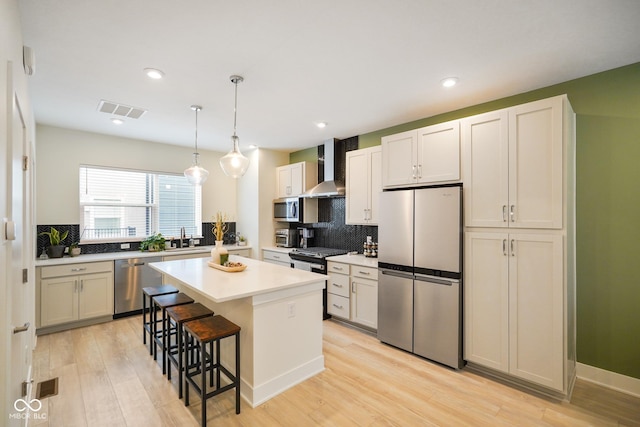 2125 Coretta Way, Indianapolis, IN 46202 - kitchen featuring appliances with stainless steel finishes, wall chimney range hood, a kitchen breakfast bar, tasteful backsplash, and recessed lighting