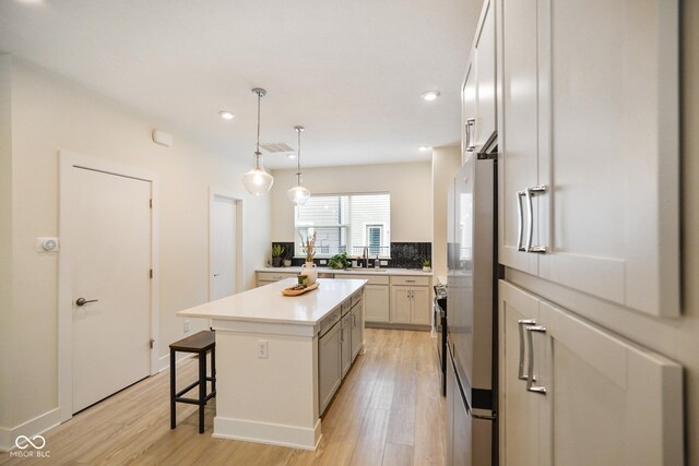 2125 Coretta Way, Indianapolis, IN 46202 - kitchen with a kitchen bar, light wood-style flooring, light countertops, a center island, and recessed lighting