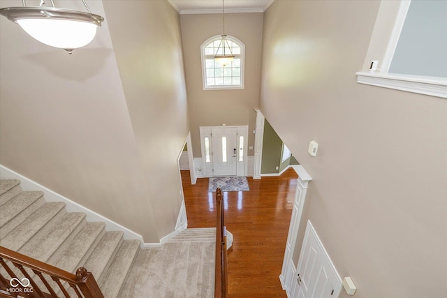 12772 Tram Ln, Carmel, IN 46032 - entrance foyer featuring wood finished floors, a high ceiling, stairway, and crown molding