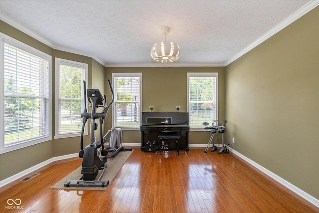 12772 Tram Ln, Carmel, IN 46032 - exercise room with hardwood / wood-style flooring, a textured ceiling, a chandelier, and crown molding