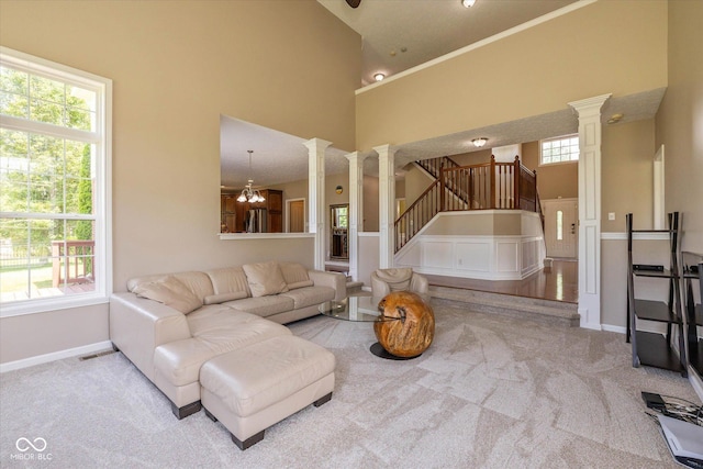 12772 Tram Ln, Carmel, IN 46032 - carpeted living room featuring decorative columns, a towering ceiling, and stairs